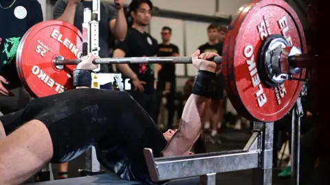 WHITE LIGHTS MEDIA Hayden Simmons bench pressing in former powerlifting competition