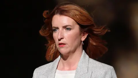Louise Haigh pictured in a light grey suit walking up Downing Street