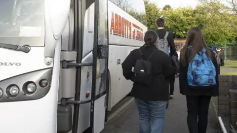 North Yorkshire Council The backs of three children walking off a white school bus