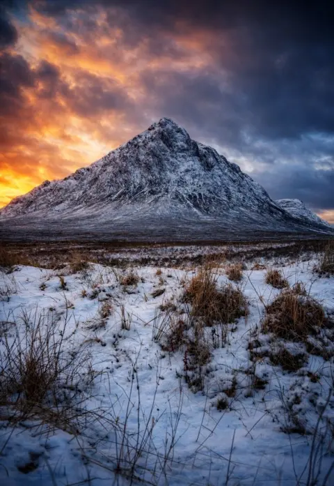 Cheryl Tracey Buachaille Etive Mòr mountain in the Highlands, with the sky lit up in pink, purple and orange colours 