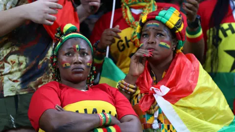 Two Ghana fans watch a World Cup match