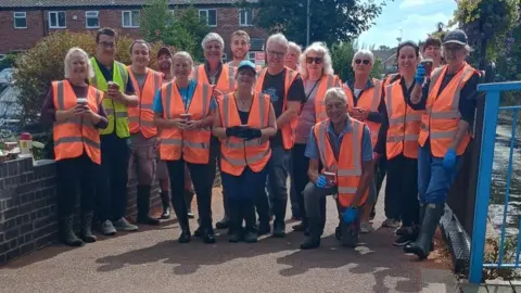 Syston Community Flood Group Syston Community Flood Group volunteers pose for a picture in orange high viz