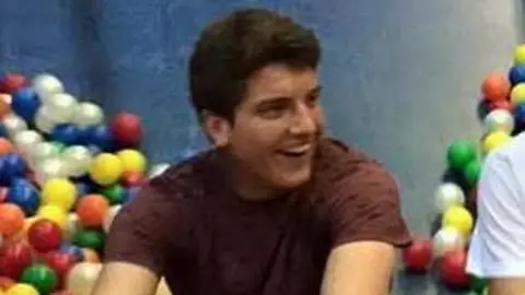 Oliver-James Gratton Adam Harrison laughs while sat in front of a collection of multi-coloured balls.
