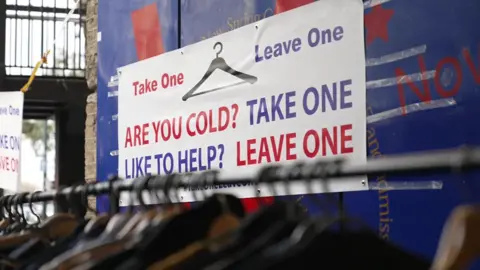 Take One Leave One banner above clothes rail