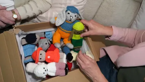 A box full of knitted rabbits and teddy bears