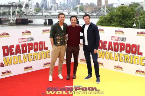 Disney Ryan Reynolds (D) com o diretor Shawn Levy (centro) e Hugh Jackman (E)