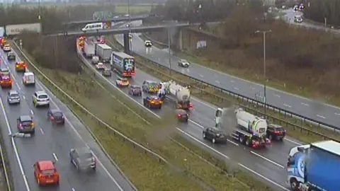 Traffic England Congestion up to junction eight of the A14. Lorries and cars are nearly bumper to bumper on the road. There are rain droplets on the camera lens.