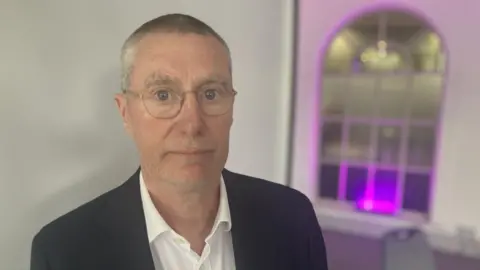 Anthony May, Chief Executive of Nottingham University Hospitals NHS trust, wearing a black jacket and white shirt 