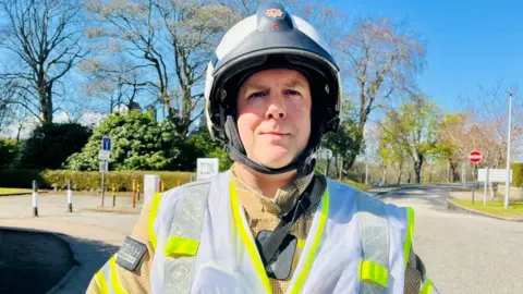 Scottish Fire and Rescue Service (SFRS) station commander Mike Elder in uniform at scene of hospital fire.