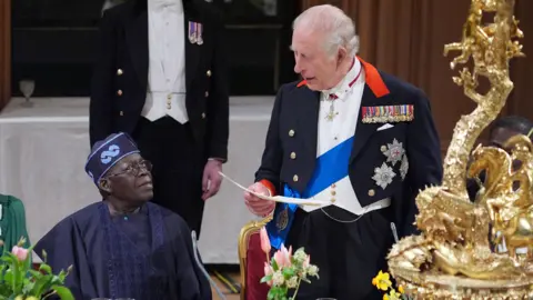 PA Media King Charles delivers his speech as President Tinubu sits listening beside him during a state banquet at Windsor Castle