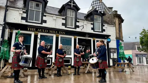 Pipe band outside The Auld Mill Inn 