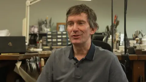 Dean Humphrey - a man in a grey polo top with brown and grey hair.