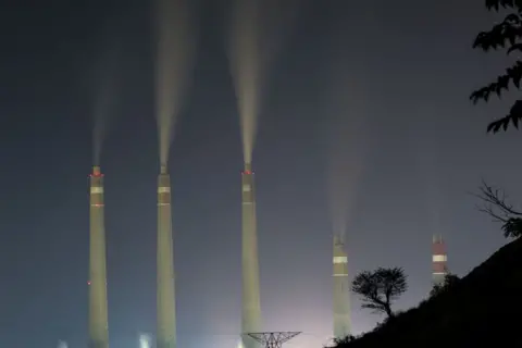 Getty Images View of Suralaya pembangkit listrik tenaga batubara sementara asap dan uap uap terlihat dari desa Suralaya di provinsi Banten, Indonesia