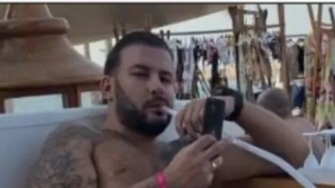 CPS handout A topless image of Harding at a bar smoking a Shisha pipe