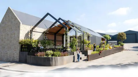 An illustration of how Homefields could look. A modern barn style building with glass and cladding. There is an outdoor space at the front of the building and lots of plants visible around the building.