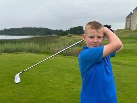 Boy with golf club at Lough Erne Resort