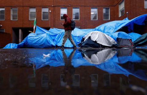 A man walks past asylum seeker tents