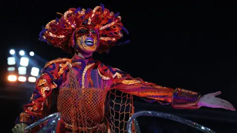 Getty Images A member of Acadêmicos do Grande Rio performs during 2026 Carnival parades at Sapucai Sambodrome.