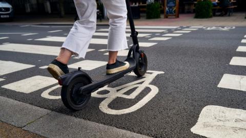 An e-scooter (not a branded Zipp e-scooter) crossing a bike path