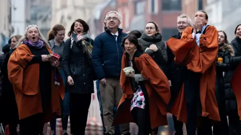 PA Media People take part in rolling hard boiled eggs on Fleet Street outside St Bride's Church