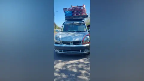 Essex Police The roof of a car packed with a large box including a pink unicorn. The car is silver 