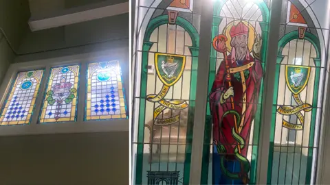 Two stained glass windows inside the museum. The one on the right is a composite of St Patrick with two banners either side - one saying '1st BN The Royal Irish Rangers' and the other says '27th Inniskilling 83rd and 87th'. The one on the left has a crown with 32 blue dots either side of it.