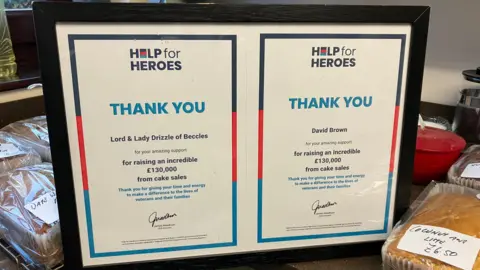 GUY CAMPBELL/BBC Two framed certificates can be seen from the Help for Heroes charity, one addressed to "Lord and Lady Drizzle of Beccles" and one to David Brown, thanking them for raising £130,000 from cake sales  