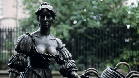 Andy Sotiriou/Getty Images The statue of Molly Malone at its original site in Dublin's Grafton Street.  The gates of Trinity College are in the background.