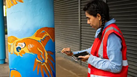 Trixiebelle Thomas TT Photography A woman painting a pillar in Farley Hill, Luton