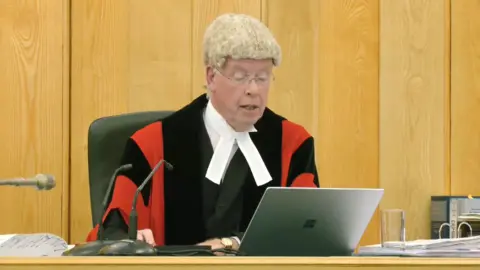Judge sat behind a laptop