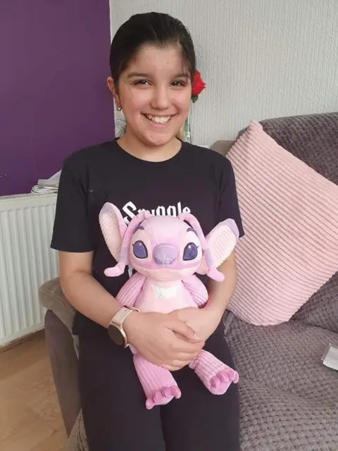 Bulpitt family Katy - young girl, smiling holding a cuddly toy