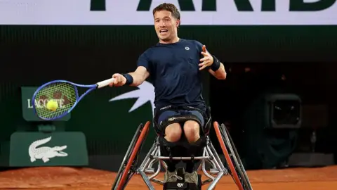Alfie Hewett is in a wheelchair and swinging a tennis racquet