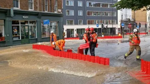 LONDON FIRE BRIGADE London Fire Brigade crews are using flood barriers to divert water caused by a burst water main on Pentonville Road.