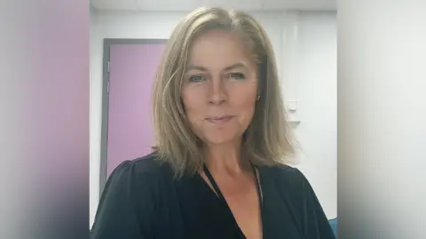 Lesley-Ann Simpson A middle-aged woman with light brown, shoulder length hair in a black shirt.