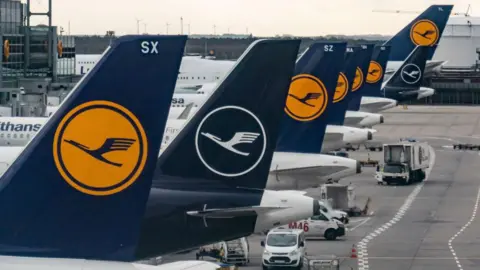 Getty Images Las aletas traseras de ocho aviones de Lufthansa estacionados en las puertas del aeropuerto de Frankfurt.