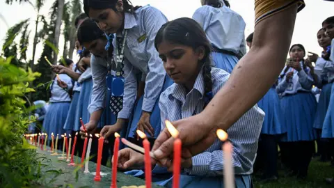 Mourners and students light candles to offer their condolences after the death of mountaineer Nirmal Purja 