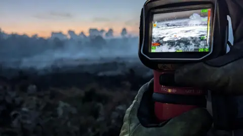HIWFRS Firefighter with heat detector at New Forest fire.