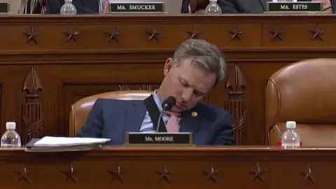 Representative Moore falls as during an hour-longs markup meeting.