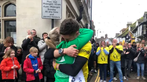 A man embraces a woman after completing a race.