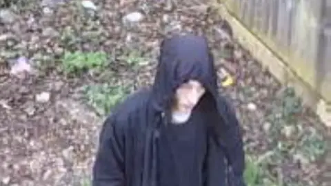 Bedfordshire Police CCTV footage of a man wearing a black hooded jacket walking 