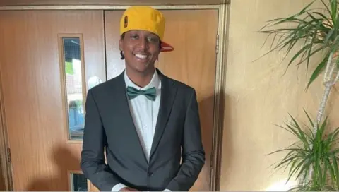 Family handout Eddie Kinuthia smiling in a bow tie and yellow cap
