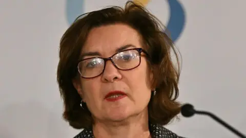 Eluned Morgan, who has short brown hair and glasses 
