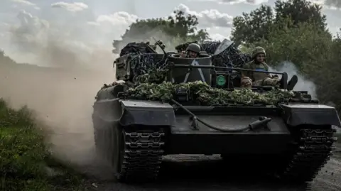 Reuters Two Ukrainian soldiers sit on top of a tank in the Sumy region