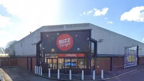 Google A Buzz Bingo industrial building. The words 'Buzz Bingo' are displayed in large around a red circle with the entrance below.