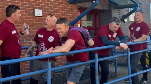 University of Bradford Firefighters leaning on railing, some laughing with each other