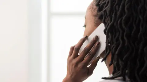 Getty Images A woman making a call with a mobile phone 