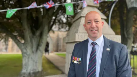 Paul Vane wearing his grandfather's medals to a church service in St John's parish