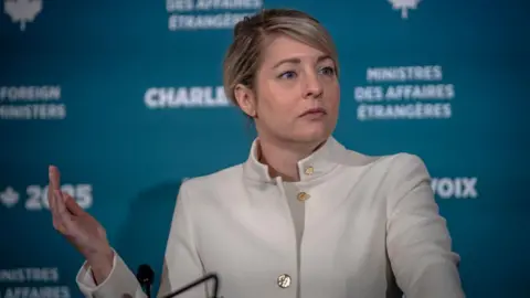 Getty Woman in white suit gestures with her right hand