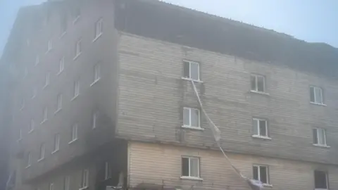 REX/Shutterstock Bedsheets hang from the top floor of the Turkish hotel where dozens of guests died in a fire