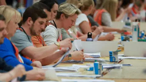 Reuters Officials count ballot papers in the Runcorn and Helsby by-election.